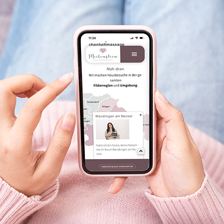 Website Relaunch Hebammenpraxis Meilenstein | Modernes Webdesign für Hebammenpraxis Smartphone mit responsiver Website der Hebammenpraxis Meilenstein. Auf dem Display ist die mobile Ansicht mit Standortkarte und Informationen zur Hebammenbetreuung in Filderstadt und Umgebung zu sehen.